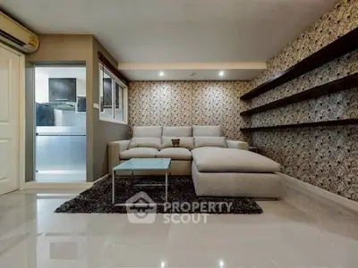 Stylish living room with modern decor and elegant wallpaper, featuring a cozy sectional sofa and sleek shelving.