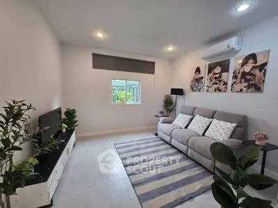 Modern living room with cozy sofa, stylish decor, and air conditioning in a bright, inviting space.
