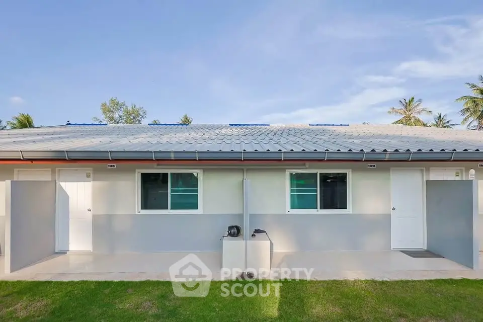 Charming single-story duplex with modern exterior and lush green lawn, perfect for serene living.
