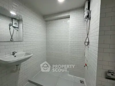 Modern minimalist bathroom with white subway tiles and sleek fixtures.