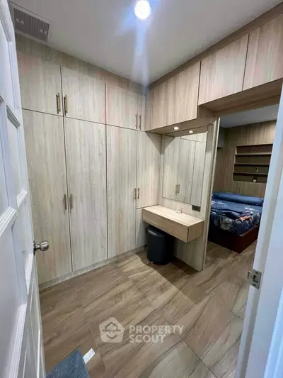 Spacious bedroom with built-in wooden wardrobes and cozy bed setup