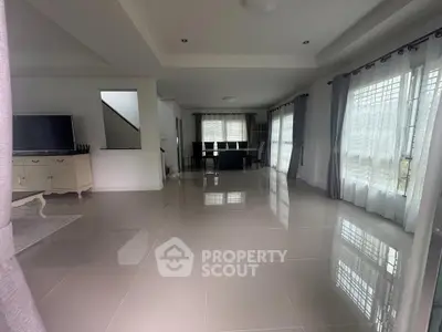 Spacious modern living room with large windows and glossy tiled floors