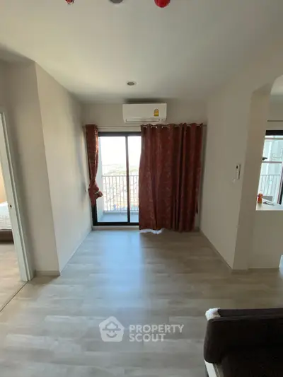 Spacious living room with balcony access and natural light