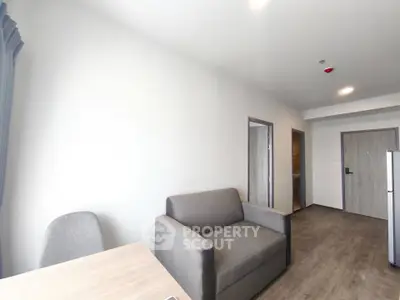 Modern living room with minimalist decor and neutral tones, featuring a comfortable sofa and sleek flooring.
