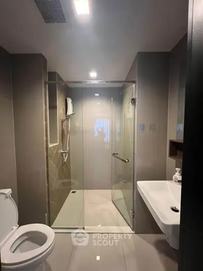 Modern bathroom with glass shower enclosure and sleek fixtures