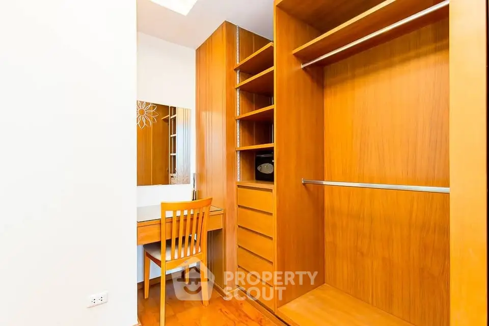 Spacious walk-in closet with wooden shelves and dressing table