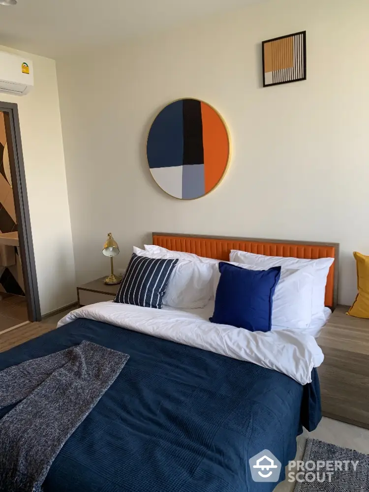 Modern bedroom with stylish decor and cozy bedding in a contemporary apartment.