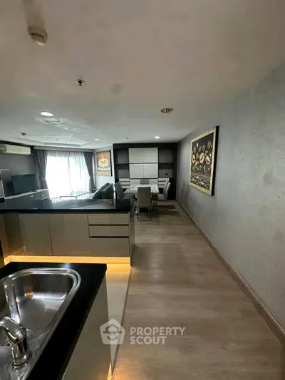 Modern open-plan living and dining area with sleek kitchen design.