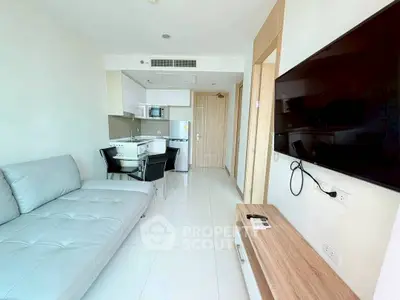 Modern living room with sleek furniture and open kitchen layout in a bright apartment.