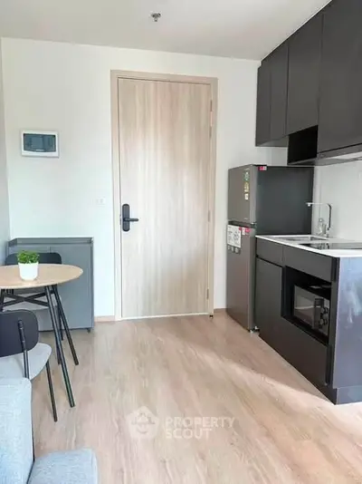Modern compact kitchen with sleek cabinetry and integrated appliances in a cozy apartment setting.