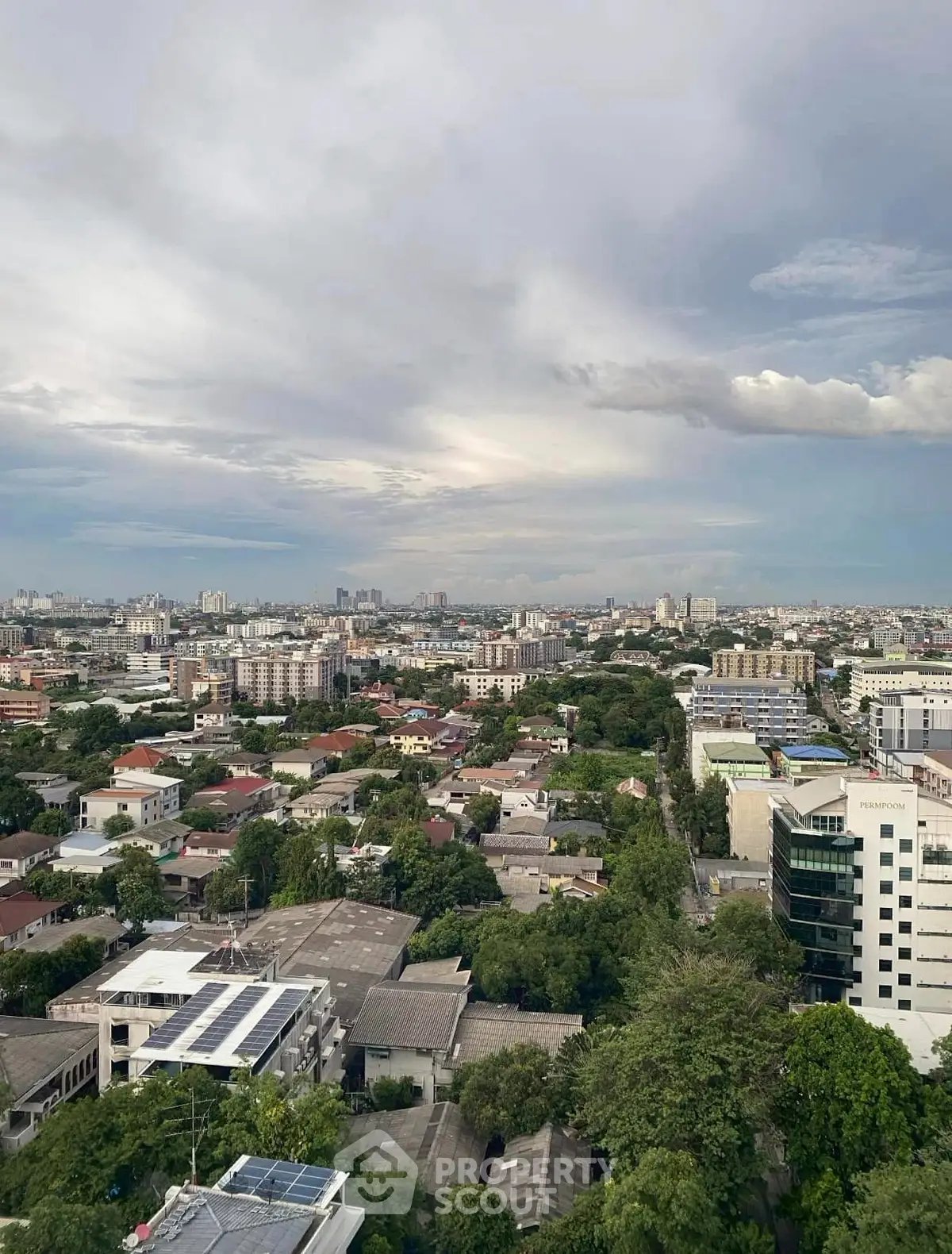 Stunning cityscape view from high-rise building showcasing urban landscape and greenery.