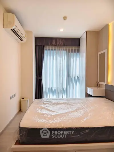 Modern bedroom with large window and air conditioning in a stylish apartment.