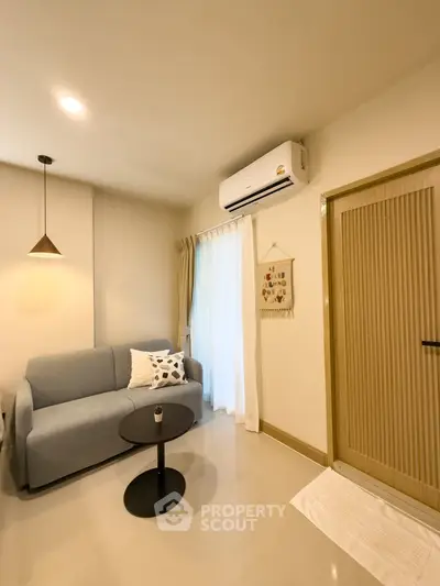 Cozy living room with modern decor and air conditioning, perfect for relaxation.