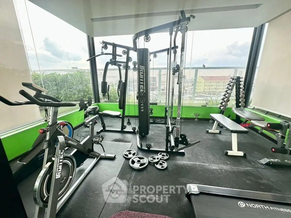 Modern gym with state-of-the-art equipment and panoramic city views, perfect for fitness enthusiasts.