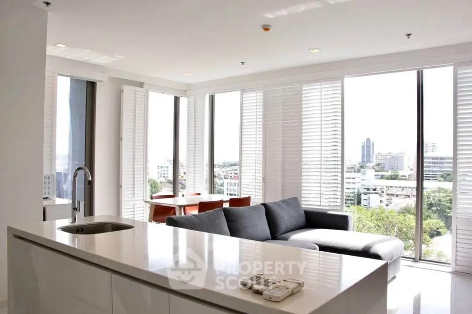 Modern open-plan living room with panoramic city views and sleek kitchen island.