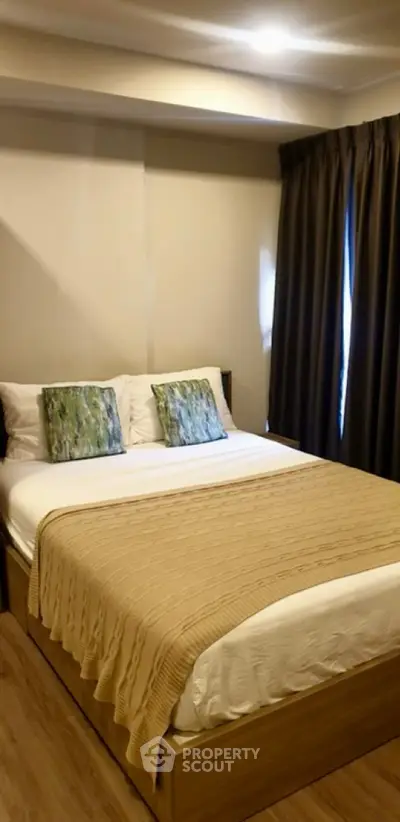 Cozy bedroom with modern decor and natural light, perfect for relaxation.