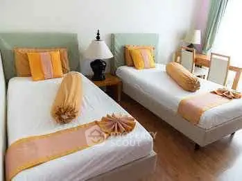 Charming twin bedroom with elegant decor and natural light, perfect for cozy living.