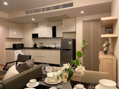 Modern open-layout kitchen and living area with stylish decor and appliances.