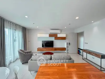 Modern living room with stylish furniture and large windows offering natural light.