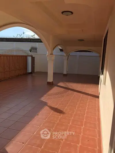 Spacious covered patio with elegant arches and terracotta tiles