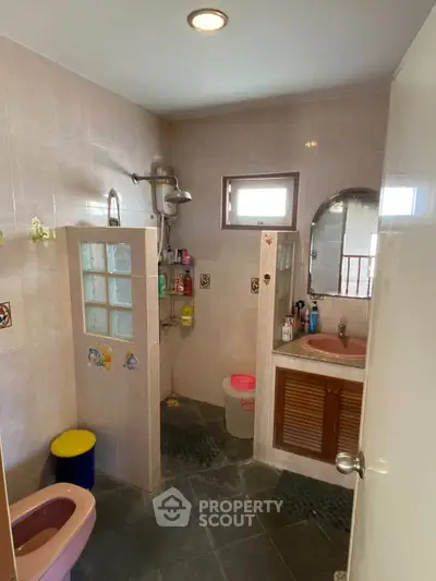 Spacious bathroom with shower and sink in a cozy home setting.