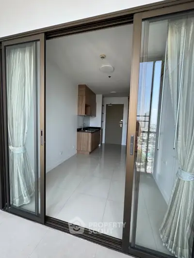 Modern apartment with sliding glass doors and sleek kitchen design, offering a bright and airy living space.