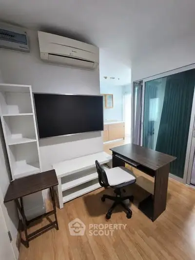 Modern study room with sleek desk, chair, and wall-mounted TV in a bright apartment.