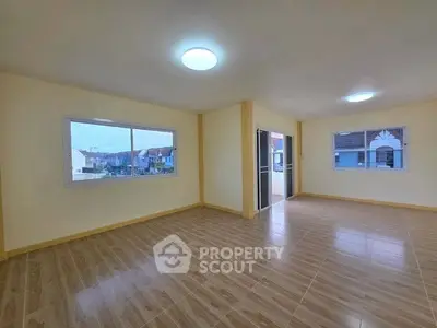 Spacious empty living room with large windows and tiled flooring, offering ample natural light and a modern design.