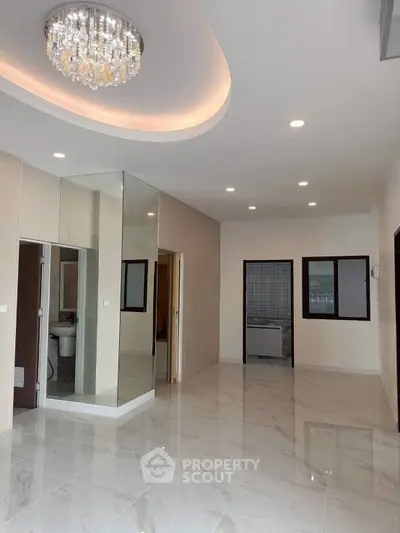 Spacious modern living room with elegant chandelier and glossy tile flooring