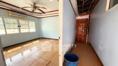 Spacious room with ceiling fan and large window, ideal for customization.