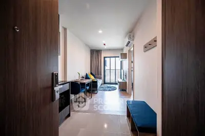 Modern apartment entrance leading to stylish living room with balcony view.