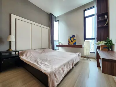 Modern bedroom with large windows and stylish decor in a luxury apartment.