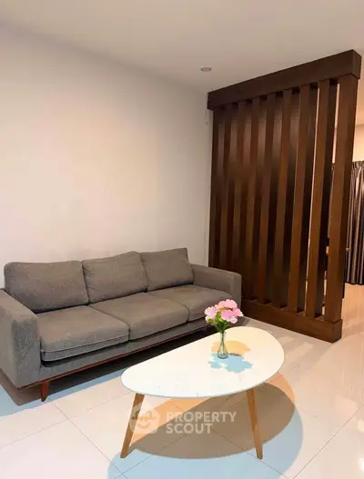 Modern living room with stylish gray sofa and chic coffee table, perfect for cozy relaxation.