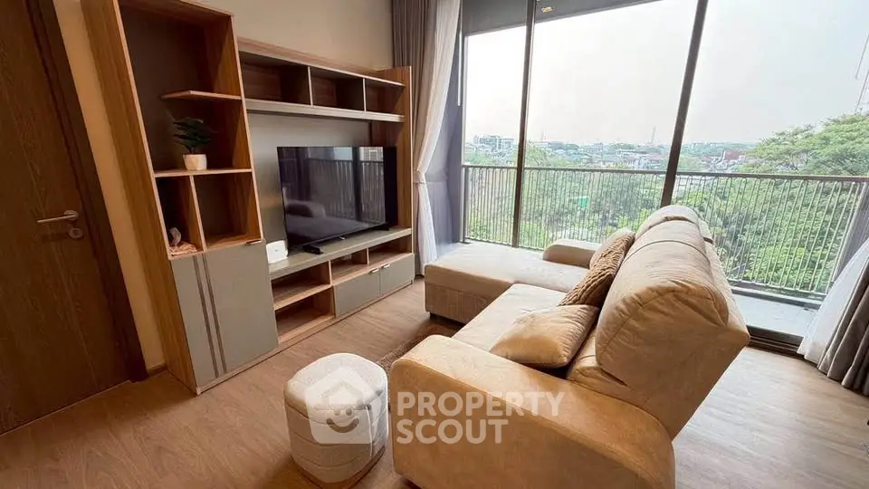 Spacious living room with modern decor and large window offering a stunning view.