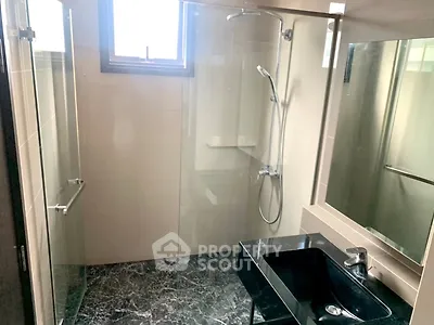 Modern bathroom with glass shower and sleek black sink