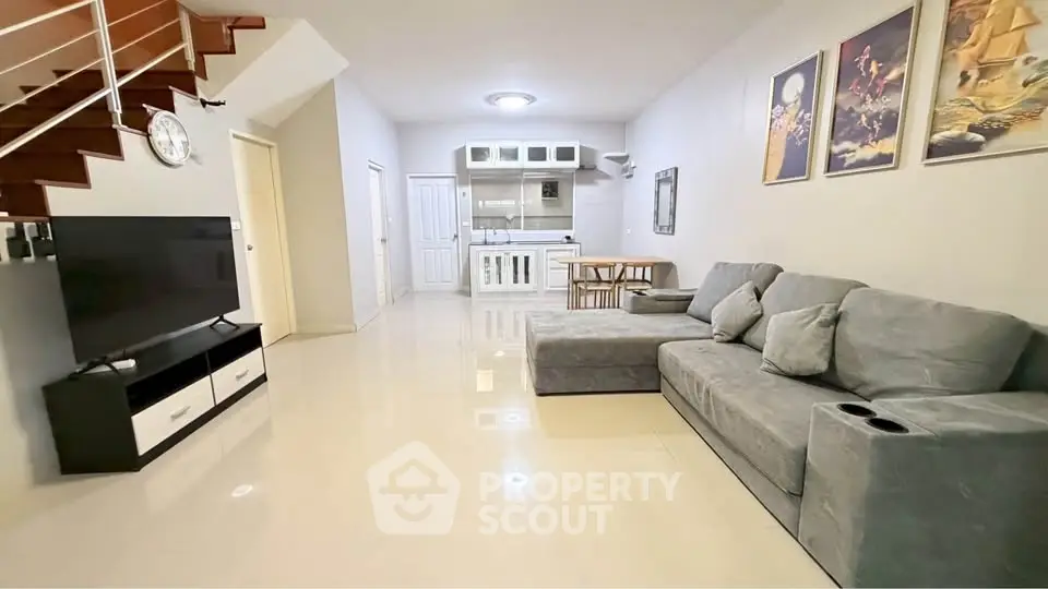 Spacious modern living room with sleek staircase and open kitchen layout