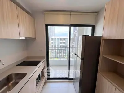 Modern kitchen with sleek appliances and balcony view in urban apartment