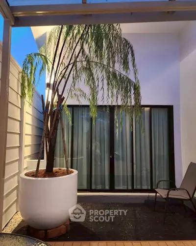 Charming patio with potted plant and seating area, perfect for relaxation and outdoor enjoyment.