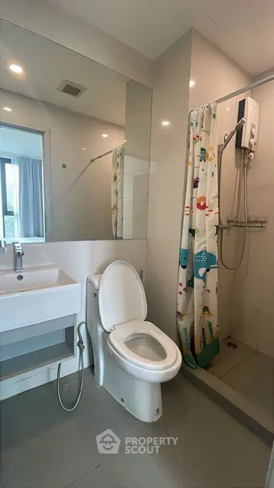 Modern bathroom with shower, toilet, and sink in a sleek design.
