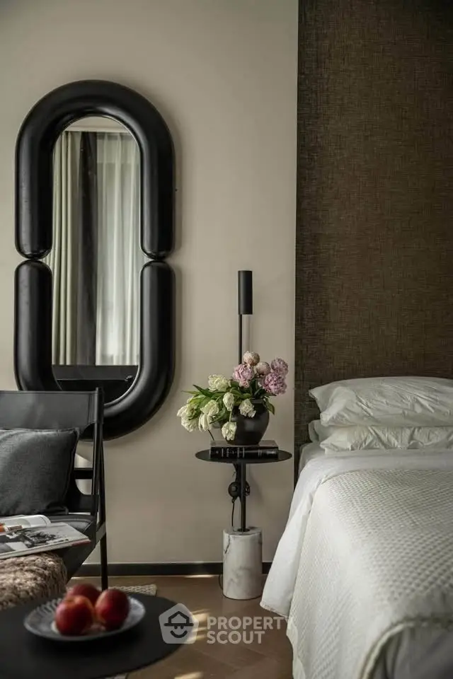 Luxurious bedroom with elegant decor and stylish furniture, featuring a unique mirror and plush bedding.