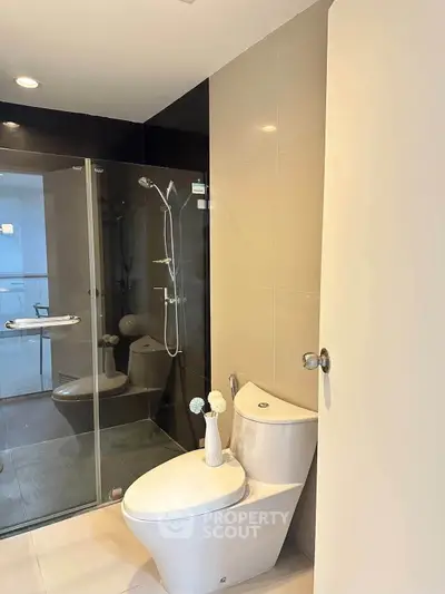 Modern bathroom with glass shower and sleek fixtures in a contemporary apartment.