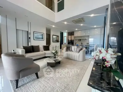 Luxurious modern living room with elegant furniture and open kitchen layout, perfect for entertaining.