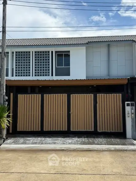 Modern townhouse exterior with gated entrance and contemporary design.