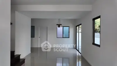 Spacious modern living room with large windows and sleek tile flooring