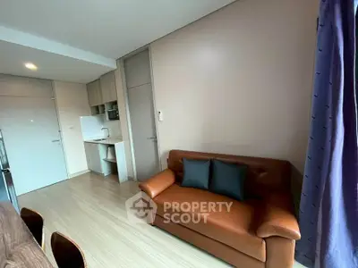 Modern living room with leather sofa and open kitchen layout