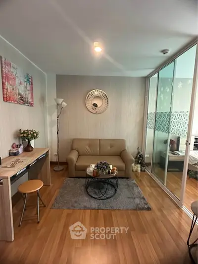 Cozy living room with modern decor and glass partition leading to bedroom