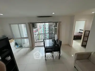 Modern apartment interior with dining area and balcony access, featuring sleek furniture and ample natural light.