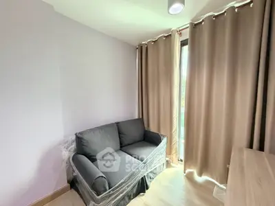 Cozy small living room with a compact sofa and large window with curtains, perfect for relaxation.
