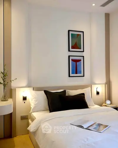 Modern bedroom with stylish decor and cozy ambiance, featuring elegant wall art and soft lighting.