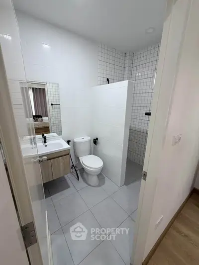 Modern bathroom with sleek design and neutral tones, featuring a shower and vanity.